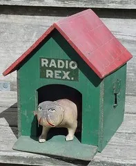 A toy dog in a green dog house labelled as 'Radio Rex'